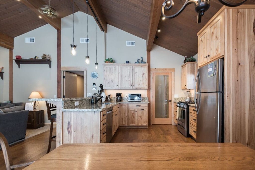 Remodeled kitchen with granite counters, wood cabinetry, and breakfast bar.