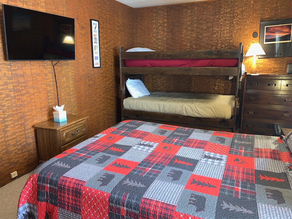 Bunk room with queen bed and twin bunk beds.