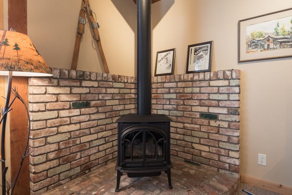 Living room gas stove set into a brick hearth.