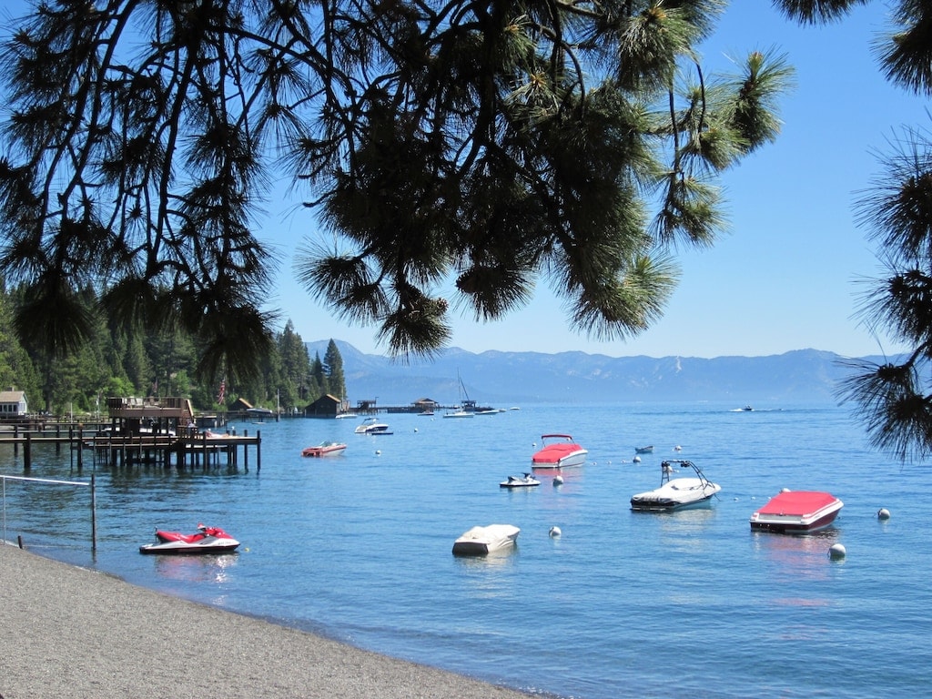Private homeowners beach on Lake Tahoe with boats and mountain views.