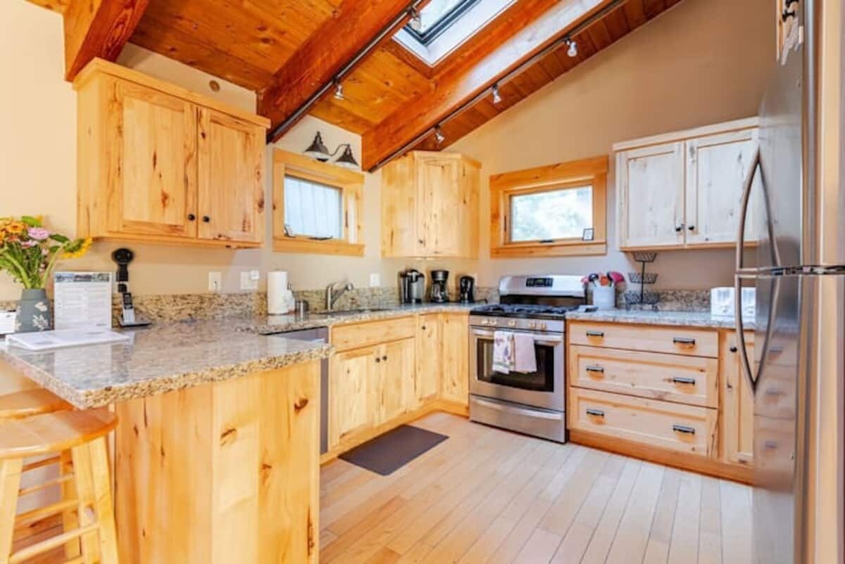 Remodeled kitchen with wood cabinetry, granite counters, and stainless appliances.