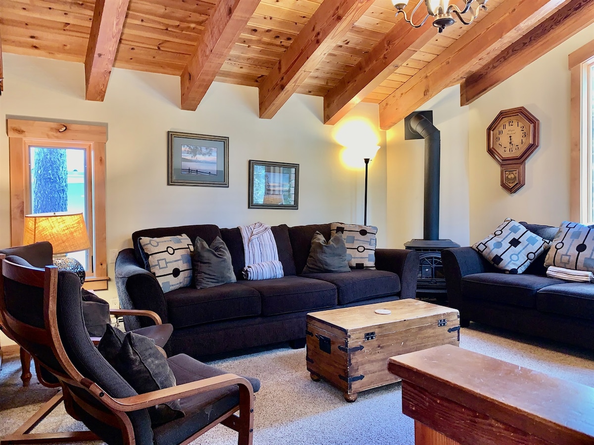 Living room with comfortable sofas and vaulted wood ceilings.