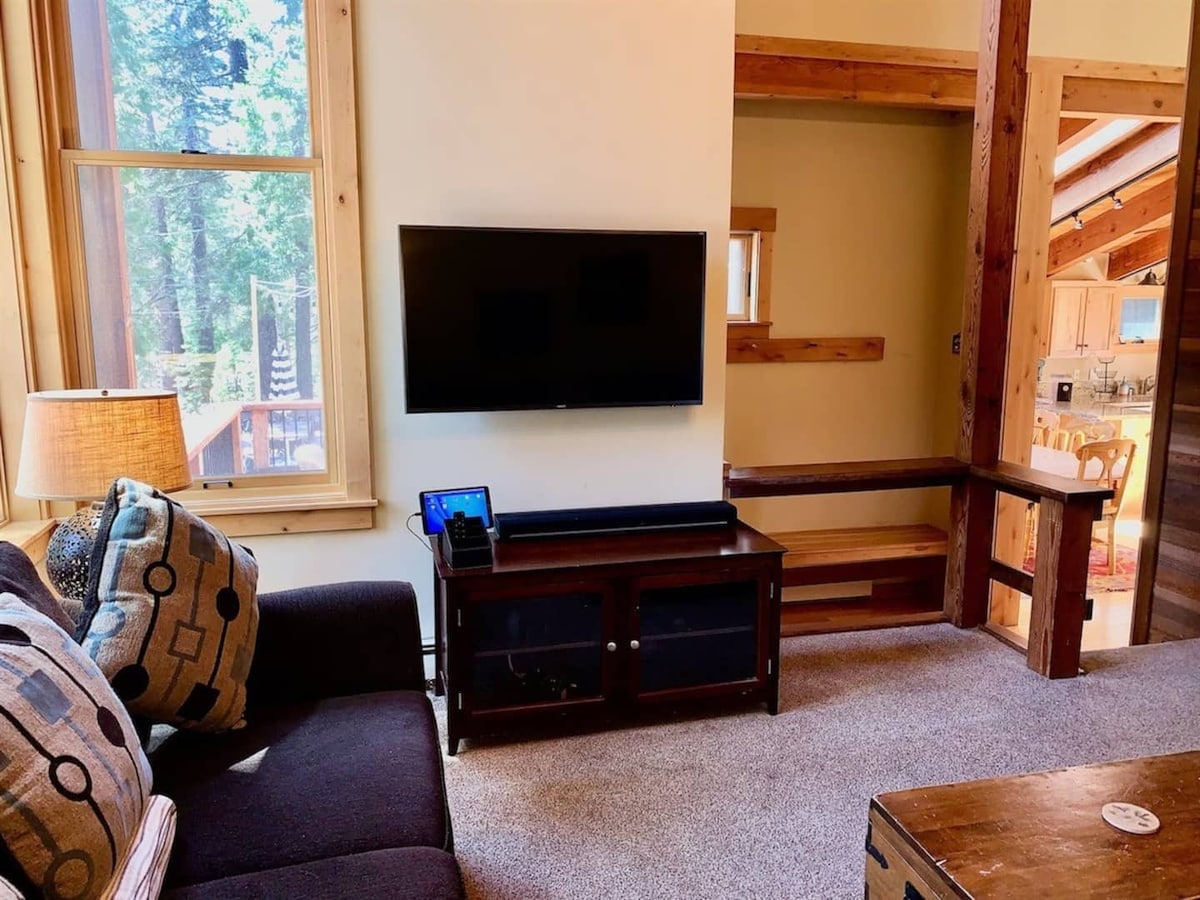 Living room TV area near the stairs and kitchen pass-through.