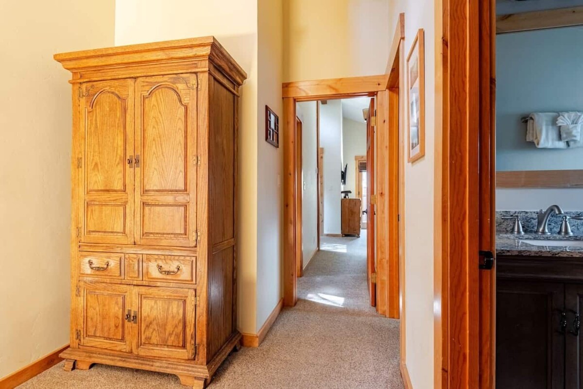 Hallway with storage armoire and bathroom access.