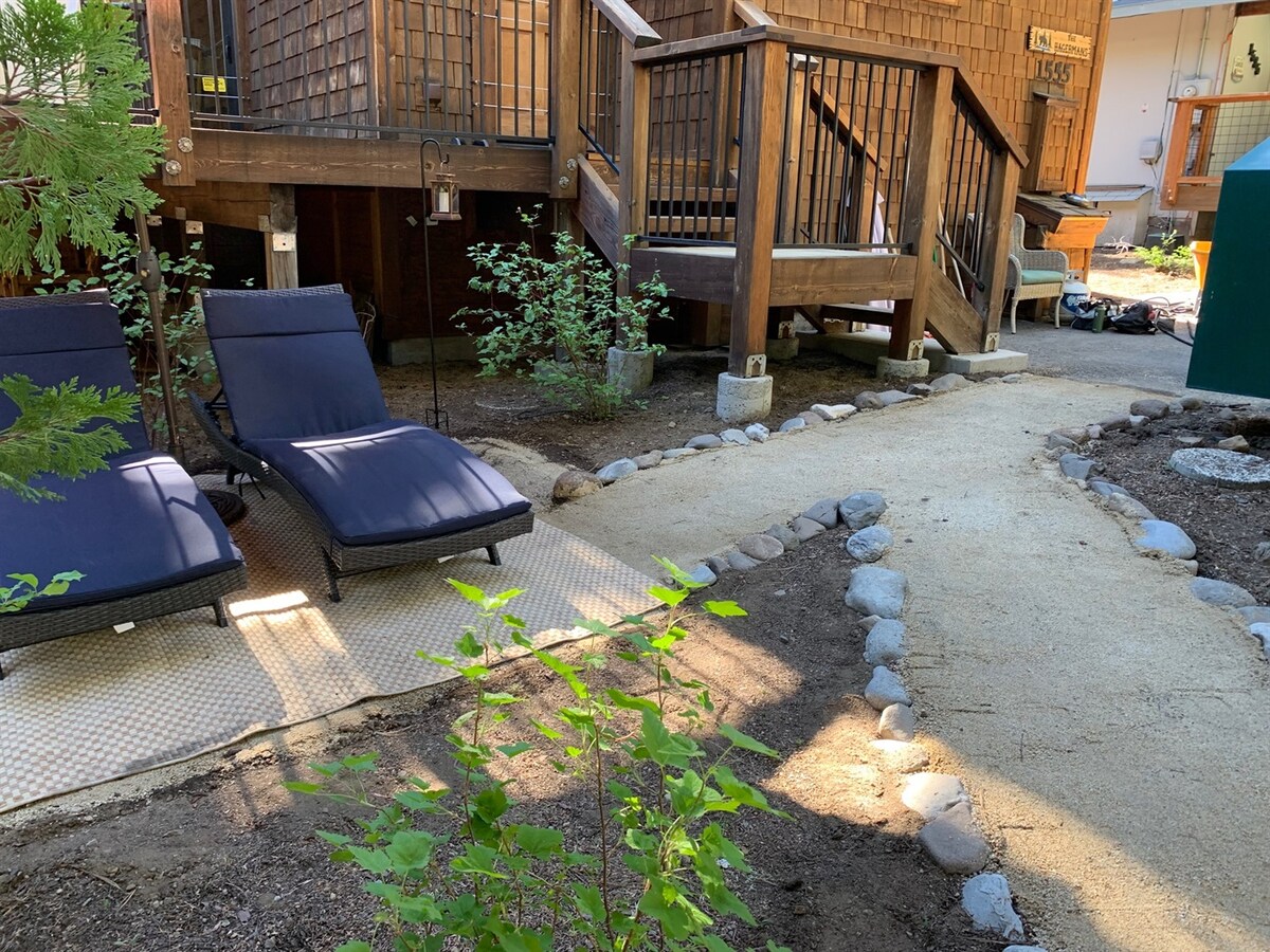 Front pathway and deck area surrounded by trees.